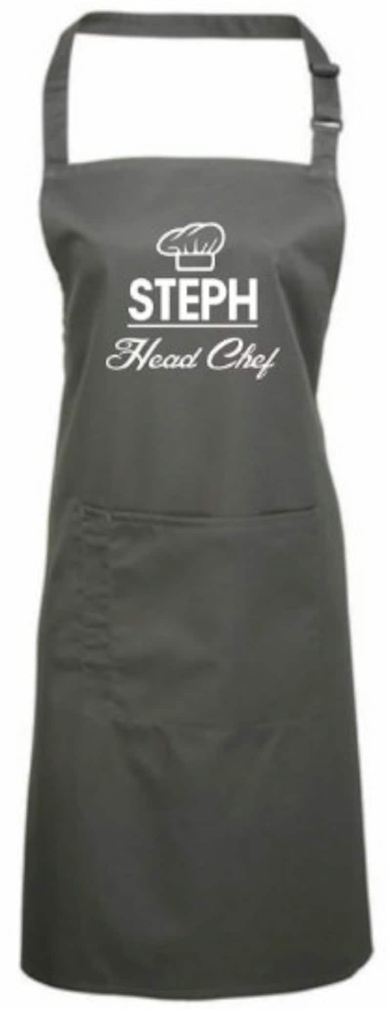 May include: A gray apron with a white chef hat graphic and the text "STEPH Head Chef".