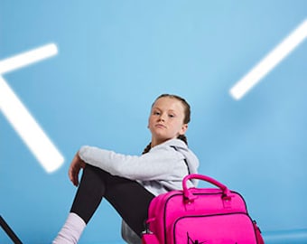 Peut inclure: Un sac de sport rose avec une silhouette noire de gymnaste et le mot "Georgia" sur le devant. Une jeune personne est assise sur le sol avec le sac à côté d'elle.