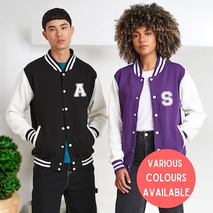 May include: Two varsity jackets, one black with white sleeves and the letter "A" on the chest, and one purple with white sleeves and the letter "S" on the chest.  VARIOUS COLOURS AVAILABLE.
