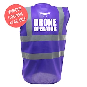 Może przedstawiać: Fioletowa kamizelka bezpieczeństwa z odblaskowymi paskami i napisem "DRONE OPERATOR" w kolorze białym z ikoną drona nad tekstem.