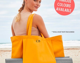 May include: A yellow canvas tote bag with the initials "CB" embroidered on the front. The bag is large enough to hold a yoga mat, which is partially visible in the image. The text "Various Colours Available" and "Yoga Mat Not Included" is also visible in the image.