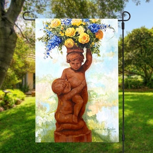 May include: A garden flag featuring a painting of two cherubs holding a pot of yellow roses and blue flowers. The flag has the text "Girl on her Garden" at the bottom.