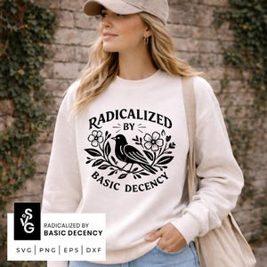 Könnte beinhalten: Cremefarbenes Sweatshirt mit dem Text "RADICALIZED BY BASIC DECENCY" in einem schwarzen, kreisförmigen Design mit einem Vogel und floralen Elementen. Das Bild enthält auch SVG-, PNG-, EPS- und DXF-Dateiformatoptionen.