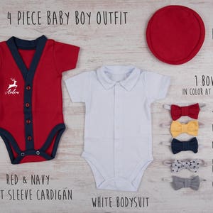 May include: A 4-piece baby outfit set including a red short-sleeve cardigan with navy trim and a white deer graphic with the name Aiden, a plain white collared bodysuit, a red round hat, and a choice of five bow ties in yellow, red, navy, gray, or gray with navy stars.