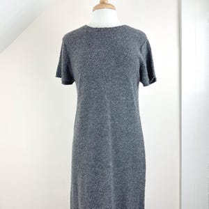 May include: A gray short-sleeved sweater dress with a round neckline.