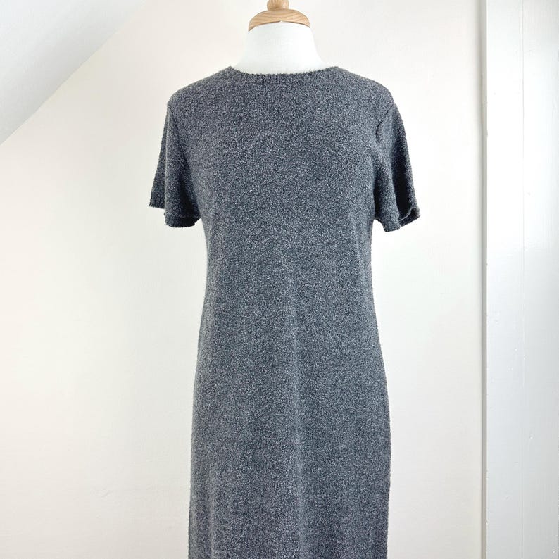 May include: A gray short-sleeved sweater dress with a round neckline.