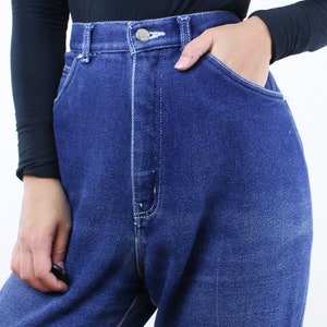May include: High-waisted blue denim jeans with a button fly and a relaxed fit.
