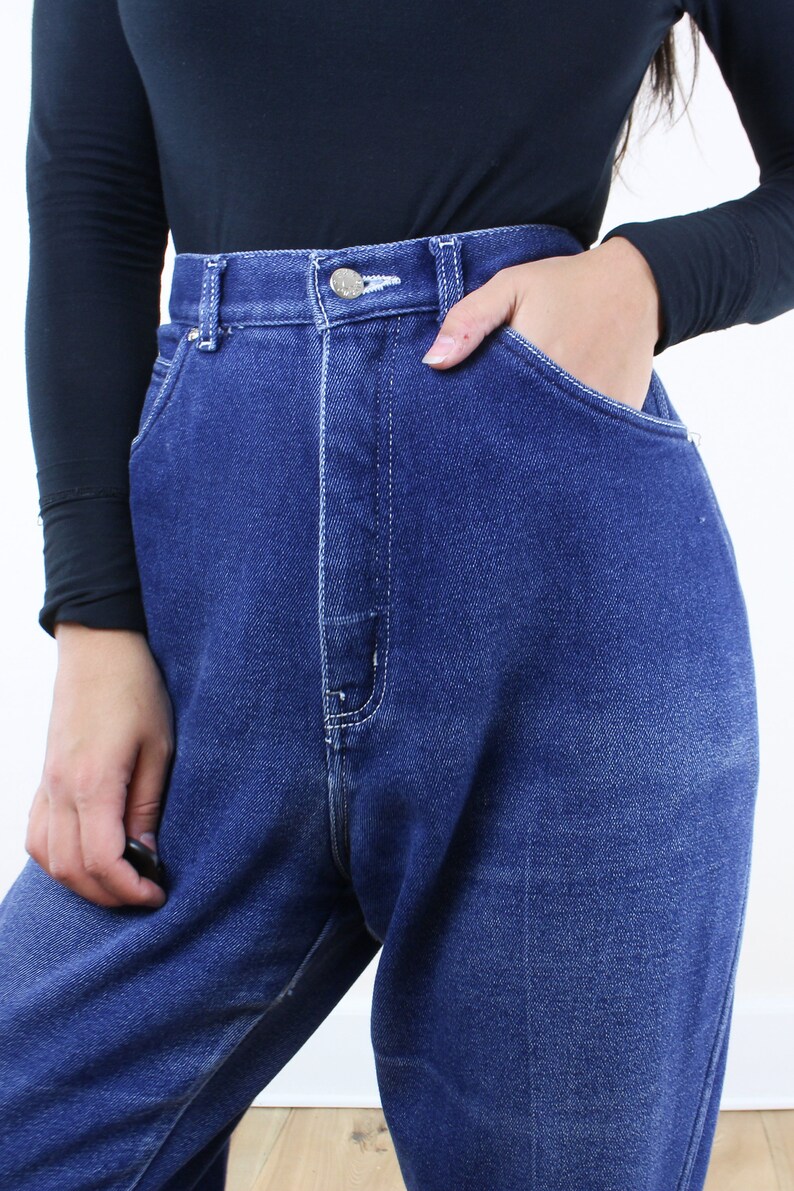 May include: High-waisted blue denim jeans with a button fly and a relaxed fit.