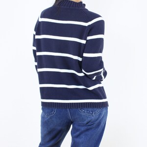 May include: A navy blue and white striped sweater with long sleeves. The sweater has a mock neck and is made of a soft, comfortable material.