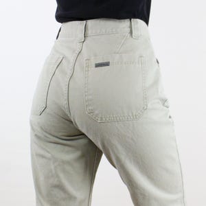May include: A pair of light beige high-waisted pants with a single back pocket.