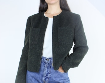 May include: A dark green cropped jacket with a zipper closure and two flap pockets. The jacket is made of a textured fabric and has a relaxed fit.