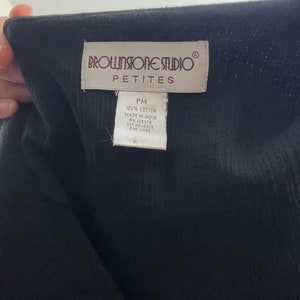May include: A white tag with brown text that reads "BROWNSTONE STUDIO&reg; PETITES PM 100% COTTON MADE IN INDIA RN 105378 SEE REVERSE FOR CARE"