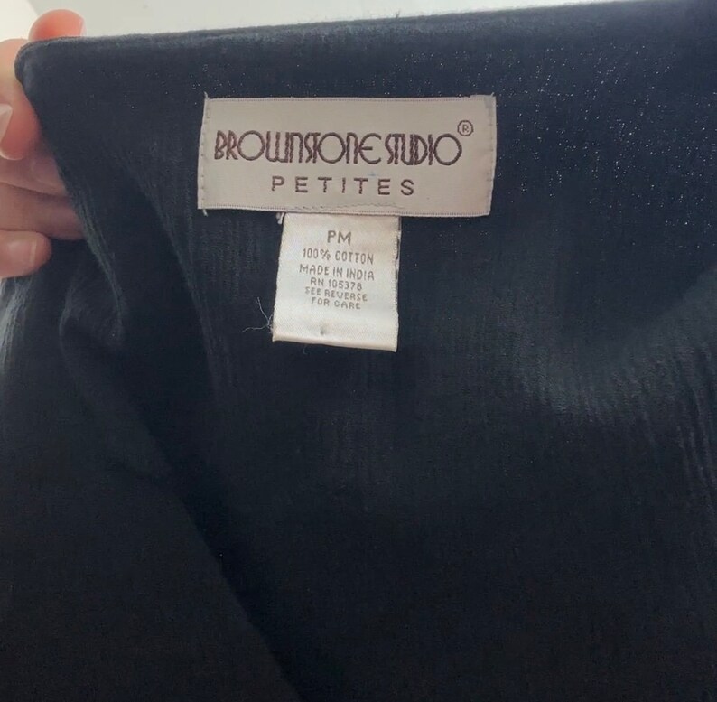 May include: A white tag with brown text that reads "BROWNSTONE STUDIO&reg; PETITES PM 100% COTTON MADE IN INDIA RN 105378 SEE REVERSE FOR CARE"