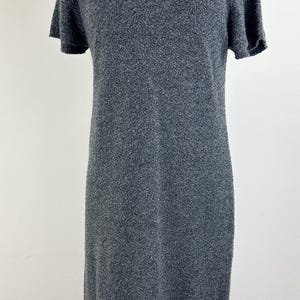 May include: A gray short-sleeved sweater dress with a textured knit fabric.