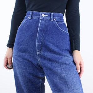May include: A pair of high-waisted, blue denim jeans with a faded wash. The jeans have a straight leg and a classic five-pocket style.