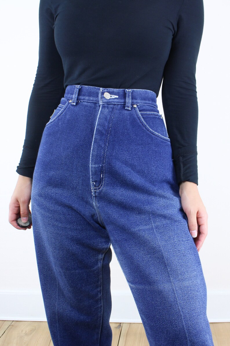 May include: A pair of high-waisted, blue denim jeans with a faded wash. The jeans have a straight leg and a classic five-pocket style.