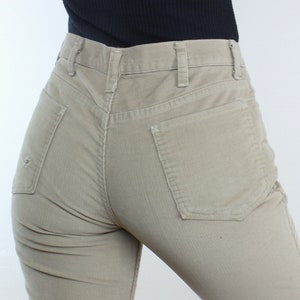 May include: A pair of light brown corduroy pants with a back pocket. The pants have a straight leg and a relaxed fit.