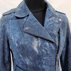 Jolie veste de motard en cuir pour femme avec fermeture éclair en métal. Veste en cuir pour femme en bleu. Veste bleue confectionnée en cuir à motifs serpent.