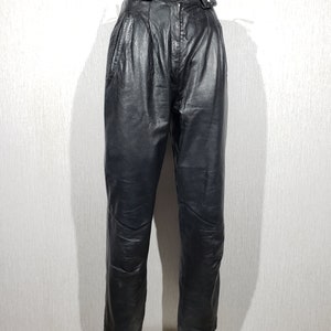 Stilvolle schwarze Lederhose für Damen. Damenhosen aus echtem Leder sind mit Zierriemen verziert.