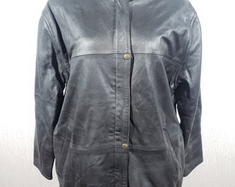 May include: A black leather jacket with a high collar and button closure. The jacket has a classic design with a slightly oversized fit, featuring two front pockets and a buttoned front. The jacket is displayed on a mannequin against a white background.