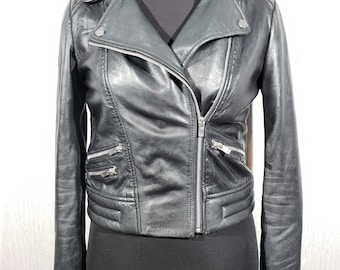 Cute women's leather jacket with a metal zipper. Biker black women's leather jacket.