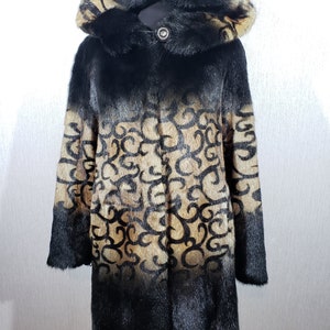 A luxurious women&#39;s fur coat with a hood. Warm brown women&#39;s fur coat made of genune fur.