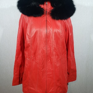 Stylish red leather jacket for women with a detachable hood. Women&#39;s delicate red leather jacket with a metal zipper.