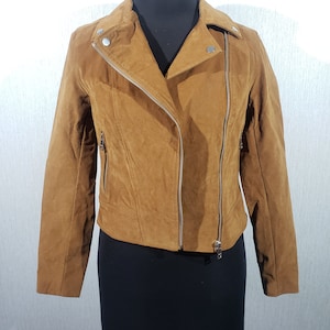 Cute women&#39;s leather jacket with a metal zipper. Women&#39;s brown suede jacket.