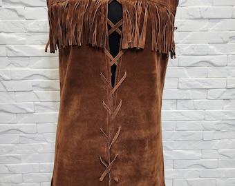 May include: A brown suede vest with fringe detailing at the top and bottom. The vest has a lace-up closure down the front. The vest is displayed on a black mannequin.