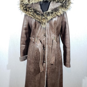 Stylish brown sheepskin coat with a warm hood. The sheepskin coat is sewn from wonderful warm sheep fur.