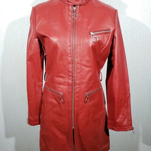 Stylish red women&#39;s leather raincoat. Cute women&#39;s leather jacket with metal zip.