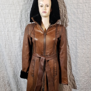 A wonderful women&#39;s warm sheepskin coat made of genuine fur. Stylish brown sheepskin coat with a detachable hood.