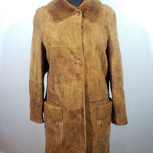 Wonderful women&#39;s warm sheepskin coat made of genuine, pleasant sheep fur. Stylish light brown sheepskin coat with leather weaving.