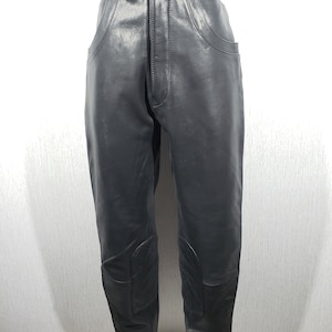 Geweldige leren zwarte bikerbroek voor heren. Zwarte leren broek met decoratieve vetersluiting.