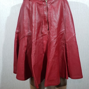 Leuk rood leren rokje. Rode leren rok met plooien.