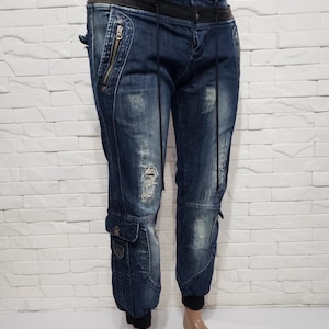 Incredible stylish men&#39;s jeans with decor. Men&#39;s denim pants of blue color, decorated with elements of other jeans.