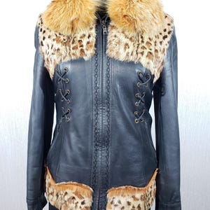 Stylish women&#39;s jacket made of genuine leather. Black women&#39;s jacket with a fur top and a fluffy collar.