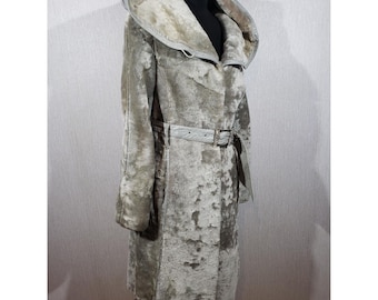 Peut inclure: Un long manteau à capuche dans une palette de couleurs gris clair et beige chiné. Le manteau présente un extérieur épais et texturé avec une doublure en peluche visible à l'intérieur de la capuche. Une ceinture assortie à boucle métallique rectangulaire serre la taille.