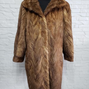 Stylish brown women&#39;s mink coat. Gorgeous women&#39;s brown fur coat made of genuine mink.