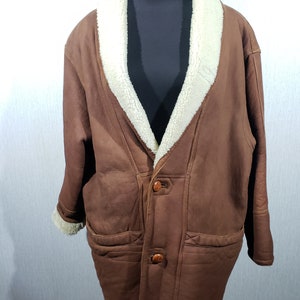 Warm stylish men&#39;s sheepskin coat with genuine fur. Brown sheepskin coat with buttons.