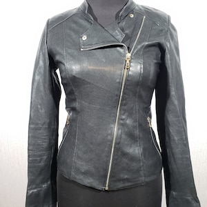 Cute women&#39;s leather jacket with a metal zipper. Women&#39;s black leather biker jacket.