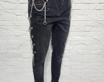 Denim damesbroek. Zwarte damesjeans met decoratieve kettingen.