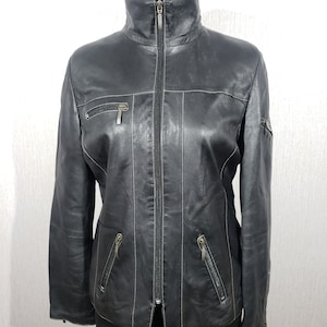 Stylish women&#39;s black leather jacket made of genuine leather. Women&#39;s black jacket with a zipper.