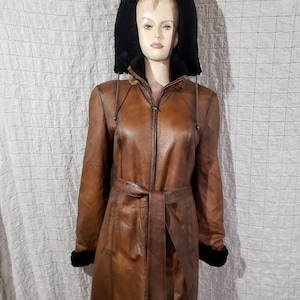 A wonderful women&#39;s warm sheepskin coat made of genuine fur. Stylish brown sheepskin coat with a detachable hood.