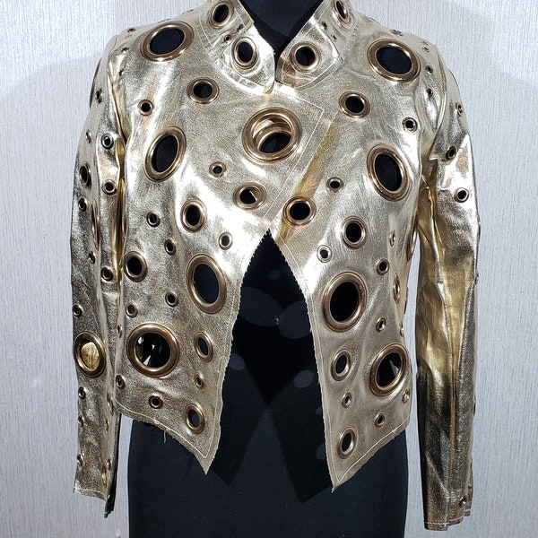 Magnifique veste pour femme en similicuir avec oeillets en métal. Veste élégante pour femme de couleur dorée, avec décoration en métal.