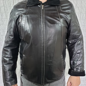 Men&#39;s sheepskin coat in black with a metal zipper. Men&#39;s strict black sheepskin coat. The sheepskin coat.