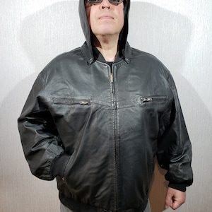 Blouson en cuir noir fiable pour homme avec poignets, col et ourlet en tricot. Blouson en cuir pour homme avec fermeture éclair et capuche. veste zippée.