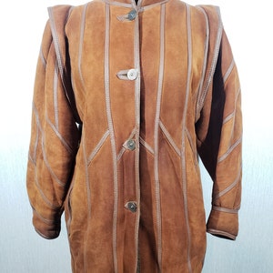 Wonderful women&#39;s warm sheepskin coat made of genuine, pleasant sheep fur. Stylish brown sheepskin coat with buttons.