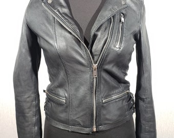 Cute women's leather jacket with a metal zipper. Biker black women's leather jacket.