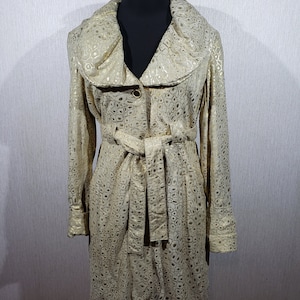 Magnifique trench-coat en cuir pour femme avec un col luxueux. Blouson en cuir pour femme de couleur dorée avec un look abstrait.